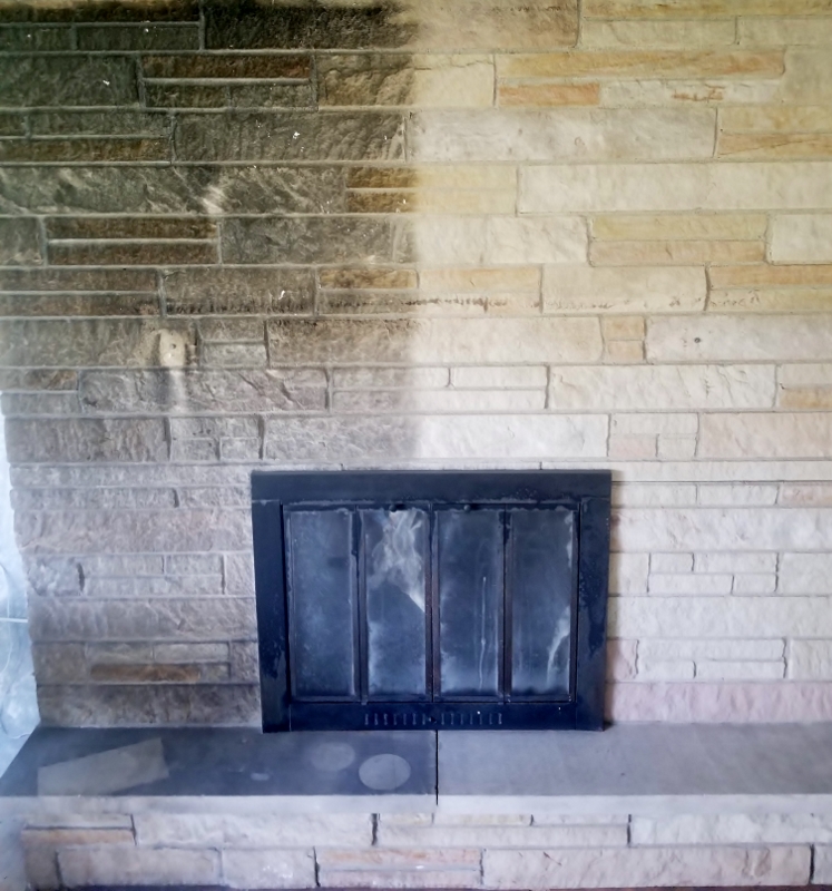 Fireplace showing smoke -damaged stone on the left and cleaned stone on the right