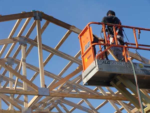 Technician removing fire damage from barn rafters