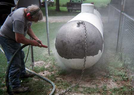 LP gas tank with paint being removed by soda cleaning