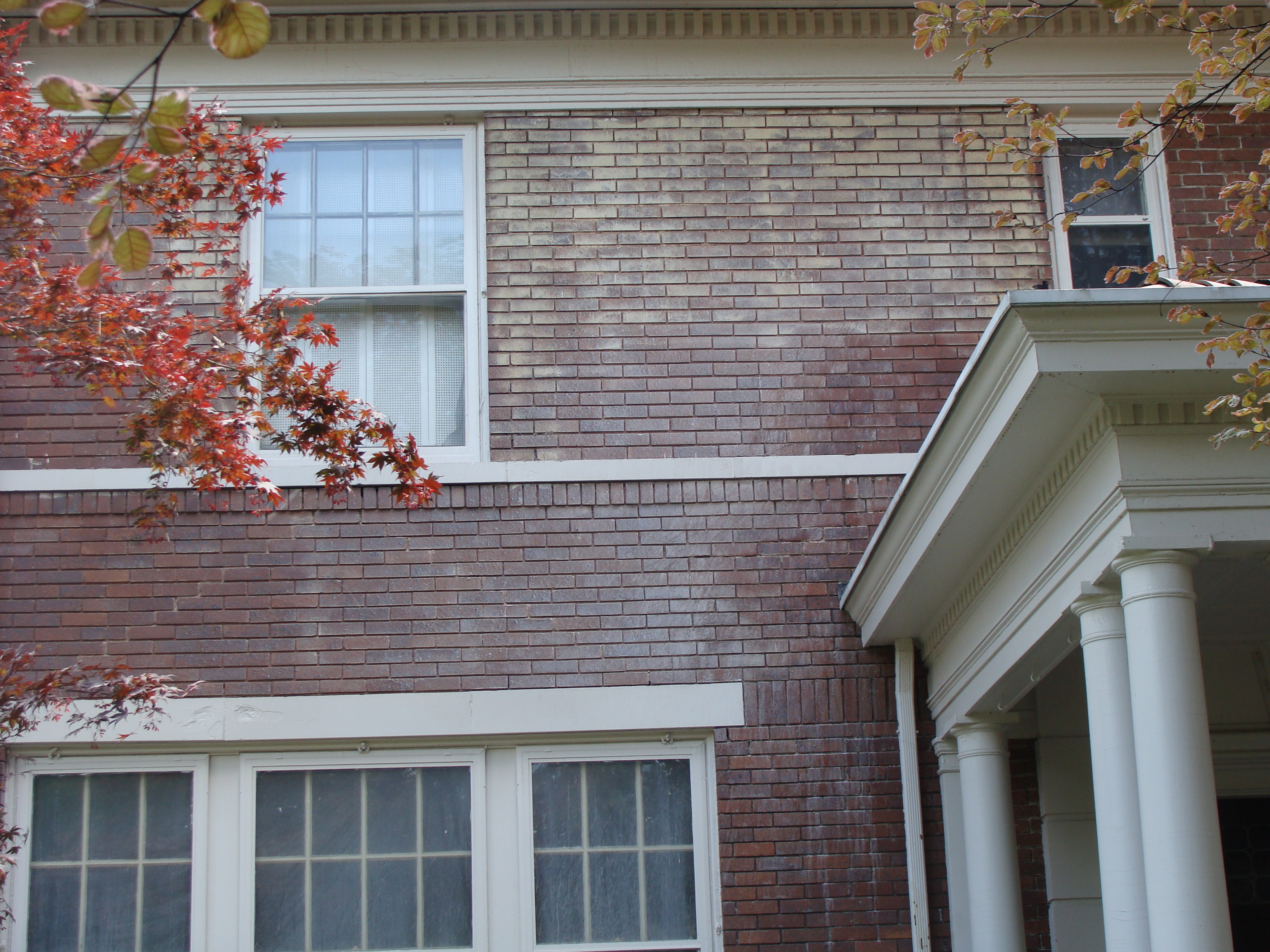 Brick home showing areas before and after soda cleaning